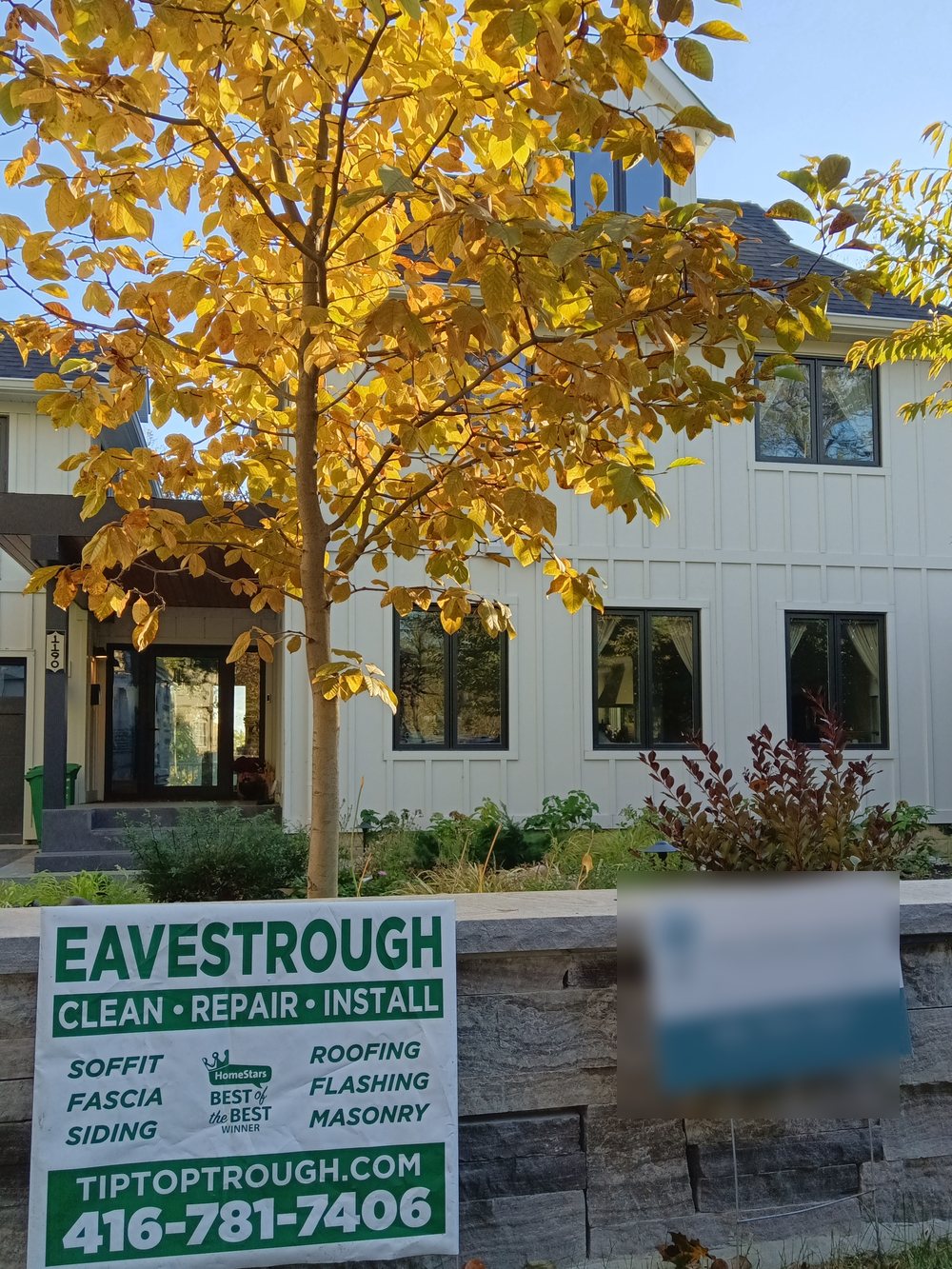 A premium home Tip Top Trough keeps clean — eavestroughs done right, with the Tip Top Trough lawn sign out front